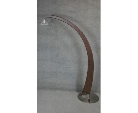 A contemporary floor standing mahogany arc reading lamp on brushed metal platform base. H.184cm 