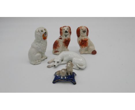 A collection of five 19th century ceramic dogs. Including a pair of Staffordshire poodles, a pair of Staffordshire spaniels a