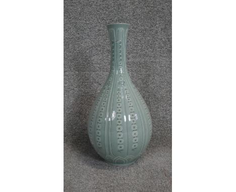 A 20th century Korean celadon glaze ceramic hand painted white flower bottle vase. Lotus petal design to bottom of vase. Arti