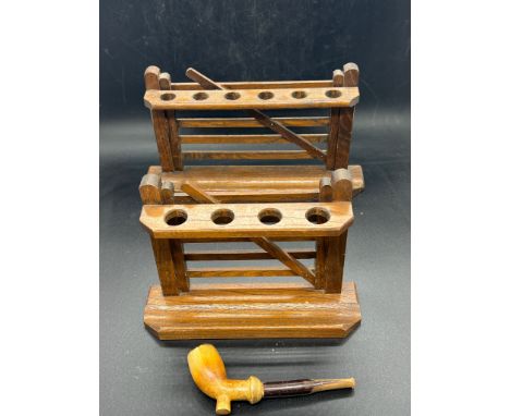 Two wooden pipe stands with one pipe 