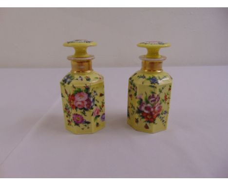 A pair of French 19th century hexagonal ceramic perfume bottles with drop stoppers decorated throughout with floral spays on 