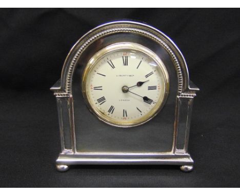 Liberty and Co. silver plated mantle clock, architectural case, circular enamel dial, Roman numerals on four bun feet