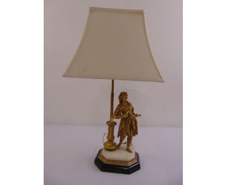 A table lamp in the form of a gilded metal figurine of a lady on elongated octagonal base to include silk shade