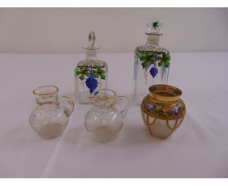 Two hand painted glass perfume bottles decorated with enamel flowers and three other decorative glass pieces