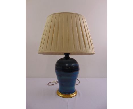A blue ceramic baluster lamp base on gilded rim foot with silk shade