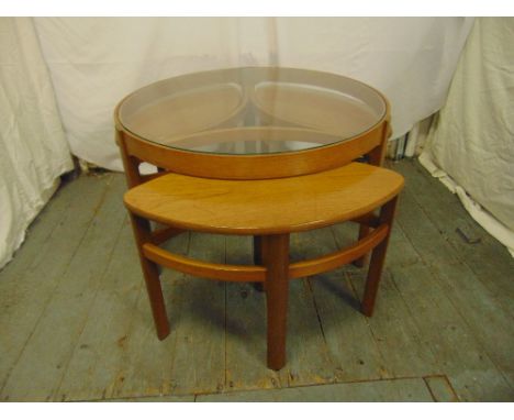 An Art Deco circular teak side table with three detachable sections and a glass top