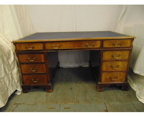 A mahogany rectangular partners desk, the nine drawers with brass swing handles on eight bracket feet