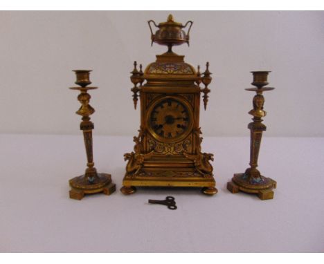 A brass and champlevé clock set with candlestick garniture brass dial, Roman numerals, two train movement, to include key and