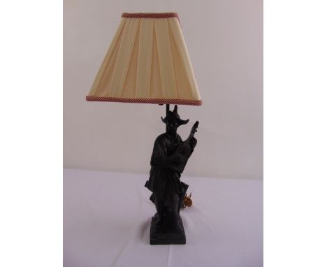 A 19th century Oriental table lamp in the form of a musician on square base to include a silk lamp shade