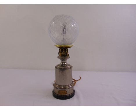 A white and gilded metal cylindrical oil lamp converted to electricity with vaseline glass globular shade