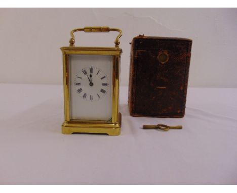 A brass carriage clock of customary form, enamel dial, Roman numerals, to include bell chime, key and case