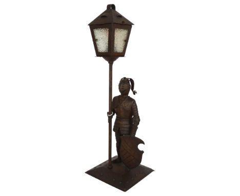 A metal sculpture of a soldier in armour the solder is attached to a lamp post fitting which has been converted into a light 