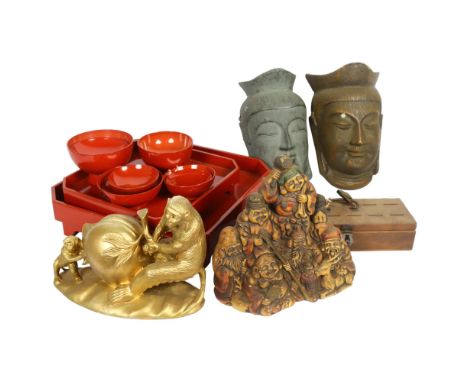 A reproduction ceramic statue of the Seven Lucky Gods, 2 similar carved wood Buddha masks, a plaster gold painted statue of a