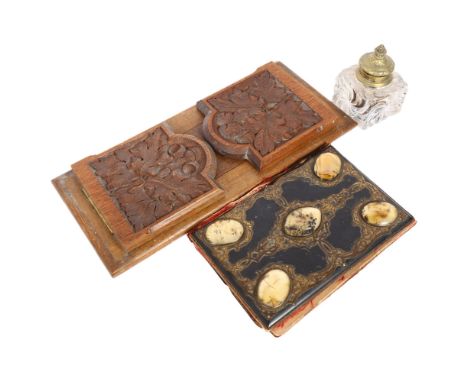 A Victorian carved oak extending book rack, a Victorian papier mache gilded desk blotter, with applied brass scroll decoratio