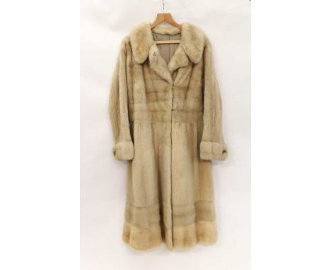 A ladies full length cream fur coat, with broad cuffs with faux pearl detail buttons, broad hem, single fastening and side po