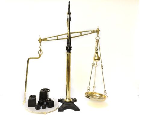 A Victorian cast iron and polished brass set  of balance scales, with a pottery dish, labelled 'Hunt & Co., with weights