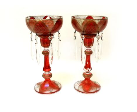 A pair of ruby and gilt candlesticks, with bowl surmount, both with clear glass drops