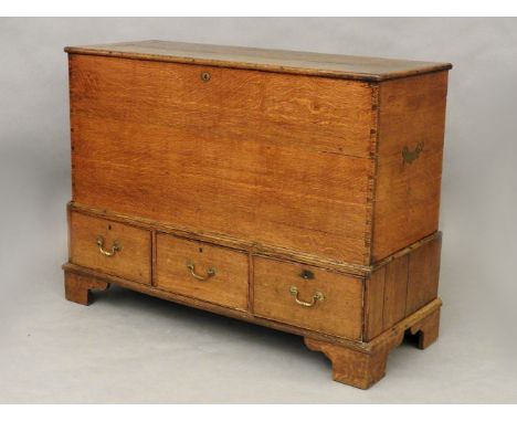An 18th century oak mule chest, the upper section with lifting lid over three drawers and standing on bracket fee, 142 x 55 x