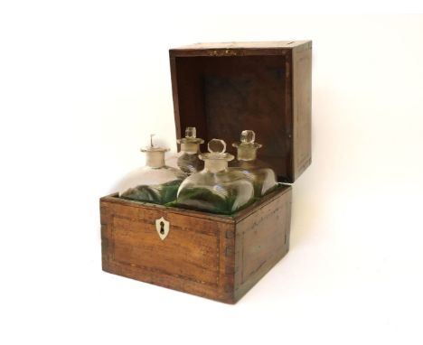 A Georgian mahogany and inlaid four bottle decanter box, the lid with shell motif opening to reveal glass square section bott