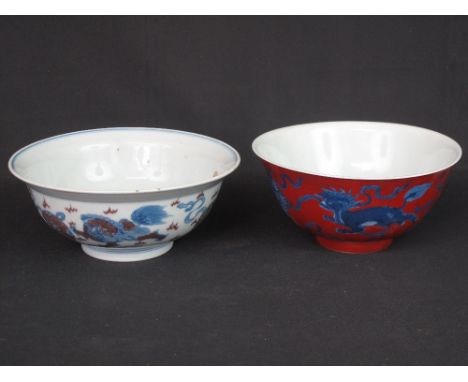 TWO CHINESE PORCELAIN BOWLS, one with everted rim, decorated externally with Dogs of Fo chasing large flaming pearls and havi