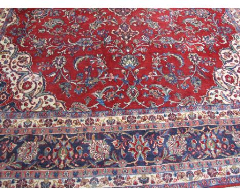 PERSIAN MESHED FOLIATE CARPET, overall decorated on a red field with scroll work and flower heads within multi-banded border.
