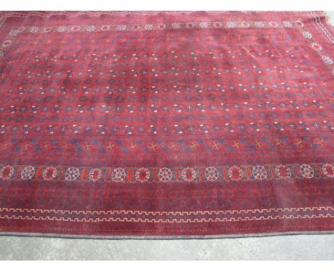 AN AFGHAN TURKAMEN BESHIR DESIGN RED GROUND GEOMETRIC RUG.  Twentienth Century 114" x 80" (290 x 204cm) CONDITION REPORT: Fad