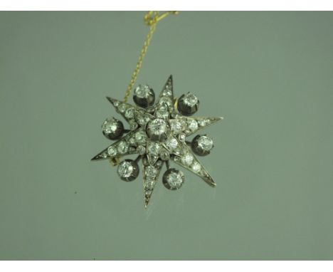 A VICTORIAN DIAMOND SET STARBURST BROOCH in silver fronted gold mount with detachable brooch fitting and clip for bail.  The 