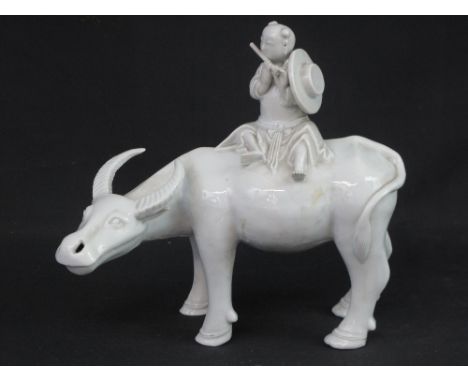 CHINESE BLANC DE CHINE PORCELAIN STUDY OF A MAN PLAYING FLUTE SEATED ON BUFFALO.  9" high (22cm) approx. CONDITION REPORT: Ra