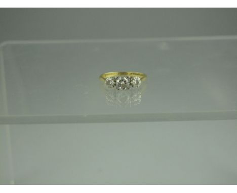 AN 18ct GOLD THREE STONE DIAMOND RING.  The platinum mounted diamonds an estimated 0.70cts in total.  Ring size L&1/2. CONDIT