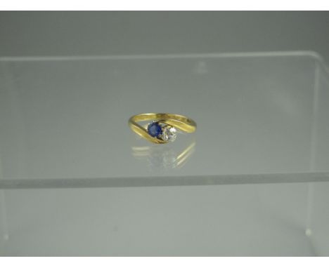 AN 18ct GOLD DIAMOND AND SAPPHIRE CROSSOVER RING.  Estimated diamond weight 0.33cts.  Ring size Q. CONDITION REPORT: In good 