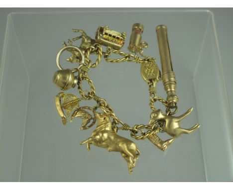 A FANCY TWIST LINK CHARM BRACELET WITH VARIOUS 9ct GOLD AND YELLOW METAL CHARMS to include a sailing boat, a pencil, a bull, 