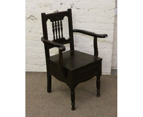 A carved and turned commode chair with ceramic liner.