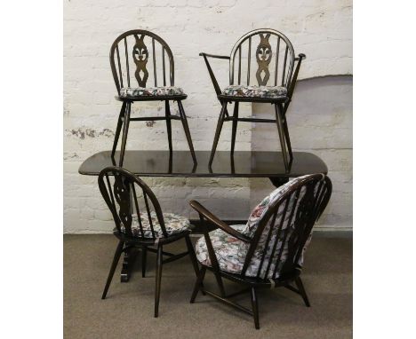 An Ercol refectory dining table, three Ercol chairs with Prince of Wales feathers motif and a similar armchair.