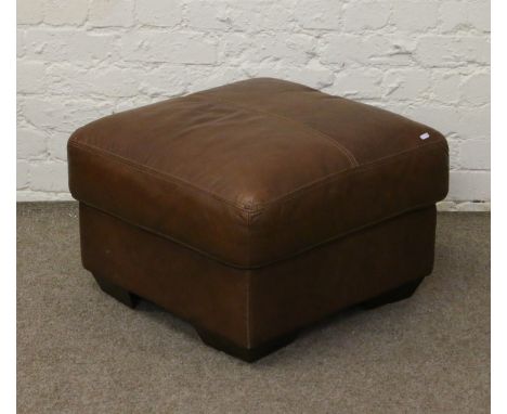 A brown leather pouffe with stitch detail.