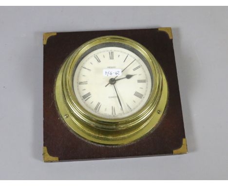 A brass cased Metamec quartz clock on mahogany back board.