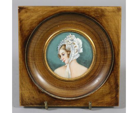 A framed ivory portrait miniature of a young woman wearing a bonnet. Monogrammed H. B. 