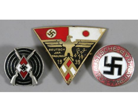 A Third Reich enamel D.A.P. badge and two similar badges.