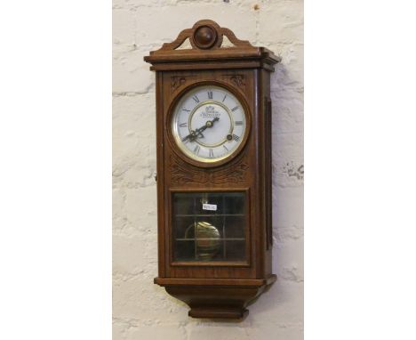 An oak cased wall clock by P Watts & Son chiming on a coiled gong.