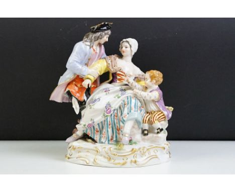 1920s German Meissen ceramic figurine group featuring a couple and child with hand painted detailing raised on a scrolled des