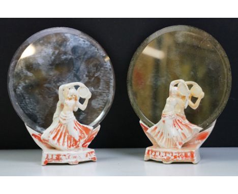 Pair of Art Deco ceramic mirror stands in the form of belly dancers, each holding a round bevelled glass mirror. Measures 18c