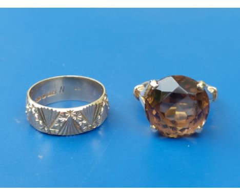 An olive brown smoky quartz 9ct gold ring, finger size K and a decorated 9ct gold wedding ring - 'Eurowed', finger size M/N. 