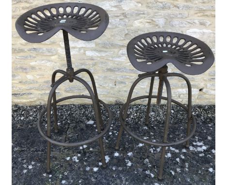 Two metal tractor seat stools approx. 70 cm high when at their lowest 