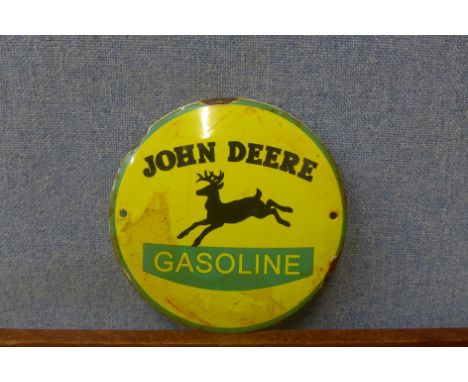 A John Deere enamelled signa and a tractor steering wheel 