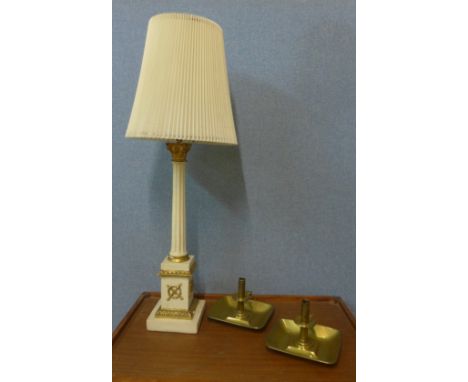 A cream and parcel gilt table lamp and two brass chamber sticks 