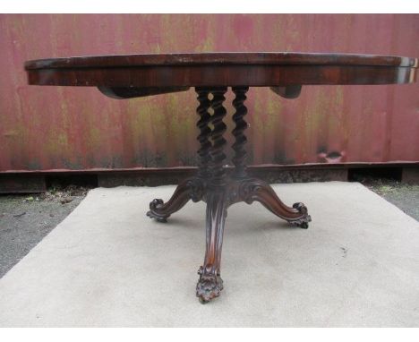 A Victorian walnut and rosewood dining table having a veneered segmented top, over three barley twist columns, raised on a tr