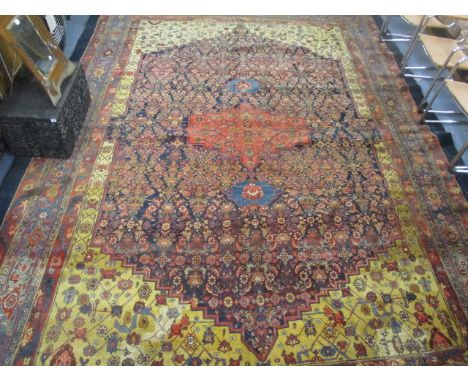 A Persian carpet with Boteh, palmets, flowers and foliage on a mustard and black ground, 168" x 120"