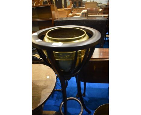 A hardwood jardiniere stand with brass planter