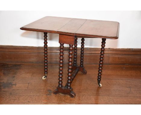 A circa 1900 Mahogany Sutherland Table standing on bobbin turned legs and having white china castors. 21 3/4'' x 5'' extendin