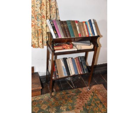 A dark Mahogany Book Trough having two levels and a central shelf, standing on brass castors. 20 5/8'' wide x 10 1/2'' deep a