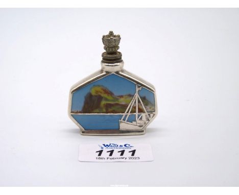 A 1930s souvenir from Gibraltar; an art deco crown top white metal and enamel scent bottle, painted with a scene of the rock 
